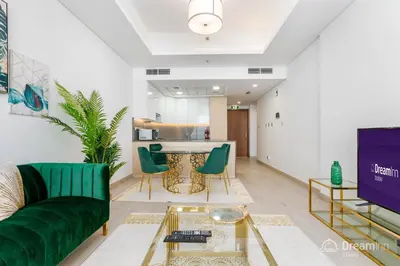 a living room with a green couch and a table at Dream Inn Apartments - Mina by Azizi in Dubai
