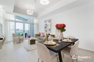 a dining room and living room with a table and chairs at Dream Inn Apartments - Mina by Azizi in Dubai