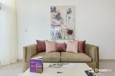 a living room with a couch with pink pillows at Dream Inn Apartments - Mina by Azizi in Dubai