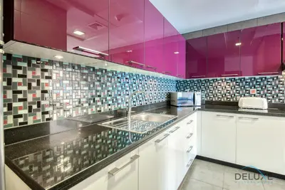 a kitchen with a sink and purple walls at Sea Views 1BR in the Heart of Dubai Marina by Deluxe Holiday Homes in Dubai