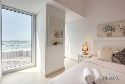 a bedroom with a bed and a large window at Sea Views 1BR in the Heart of Dubai Marina by Deluxe Holiday Homes in Dubai