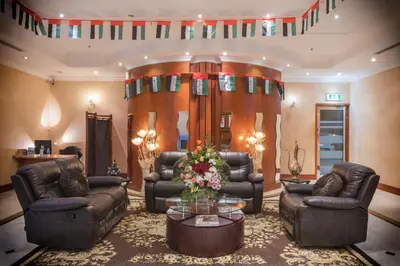 a living room with leather couches and a table at La Villa Najd Hotel Apartments in Dubai