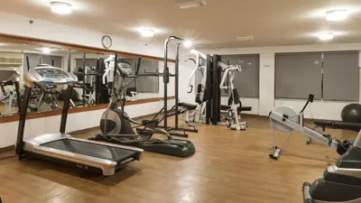 a gym with several treadmills and exercise machines at La Villa Najd Hotel Apartments in Dubai