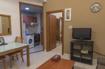 a living room with a television and a kitchen at La Villa Najd Hotel Apartments in Dubai