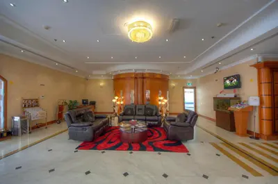 a large living room with two chairs and a table at La Villa Najd Hotel Apartments in Dubai