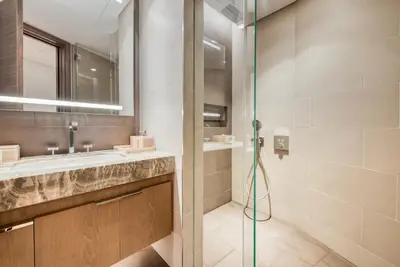 a bathroom with a glass shower and a sink at Palm Jumeirah Luxury Apartments by Propr in Dubai