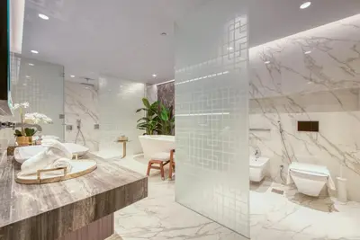 a bathroom with a toilet and a tub and a sink at Palm Jumeirah Luxury Apartments by Propr in Dubai