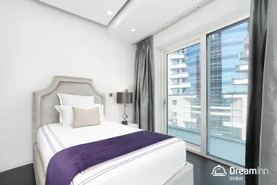 a bedroom with a bed and a large window at Dream Inn - Damac Heights by Fendi in Dubai