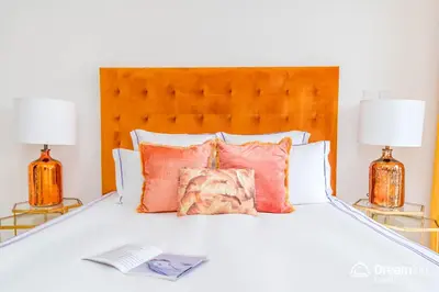 a bed with two lamps and a book on it at Dream Inn - Damac Heights by Fendi in Dubai