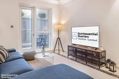 a living room with a blue couch and a tv at Peaceful Oasis 3BR+kids, 7 min walk to Dubai Mall in Dubai