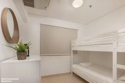 a white bedroom with a bunk bed and a mirror at Peaceful Oasis 3BR+kids, 7 min walk to Dubai Mall in Dubai