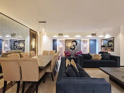 a dining room and living room with a table and chairs at Elan Murjan Rimal Suites, Sea in 3 min walk! 6 Bedrooms & Hall, Massive Layout in Dubai