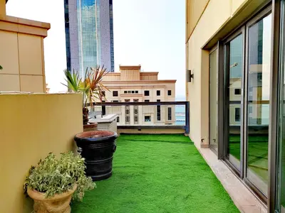 a balcony with green grass and a view of a building at Elan Murjan Rimal Suites, Sea in 3 min walk! 6 Bedrooms & Hall, Massive Layout in Dubai