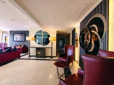 a living room with red furniture and a painting on the wall at Elan Murjan Rimal Suites, Sea in 3 min walk! 6 Bedrooms & Hall, Massive Layout in Dubai