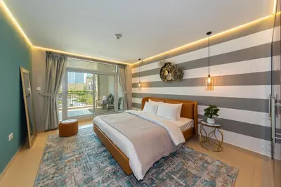 a bedroom with a bed with a striped wall at One Bedroom in Burj Views by Radiance Vacation Stays in Dubai