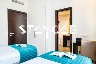 two beds in a hotel room with a book at Staycae Holiday Homes - Celestia in Dubai
