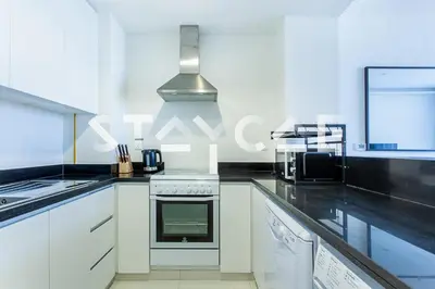 a kitchen with white cabinets and a stove top oven at Staycae Holiday Homes - Celestia in Dubai