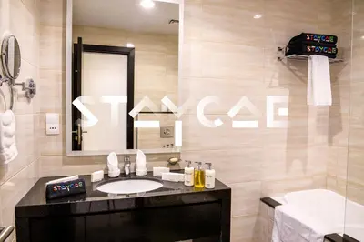 a bathroom with a sink and a mirror and a tub at Staycae Holiday Homes - Celestia in Dubai