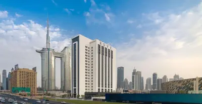 a tall white building in front of a city at Rove City Walk in Dubai