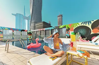 a woman sitting on a chair on a roof at Rove City Walk in Dubai