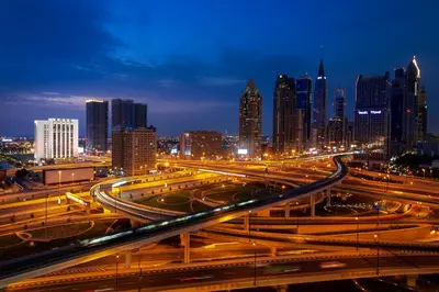 a city skyline at night with traffic on a highway at Rove City Walk in Dubai