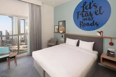 a bedroom with a bed and a sign that says lets travel new roads at Rove City Walk in Dubai