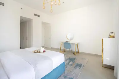 a bedroom with a bed and a table and a chair at Frank Porter - The Pulse Residences in Dubai