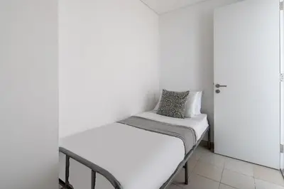a bed in a room with a white wall at Frank Porter - The Pulse Residences in Dubai