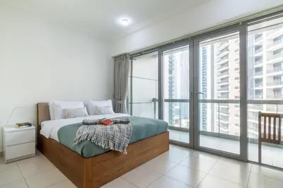 a bedroom with a bed and large windows at The Smart Concierge - 8 BLVD Walk in Dubai