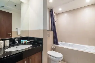 a bathroom with a sink and a toilet and a tub at The Smart Concierge - 8 BLVD Walk in Dubai