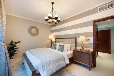 a bedroom with a bed and a chandelier at Burj Residence by Radiance Vacation Stays in Dubai