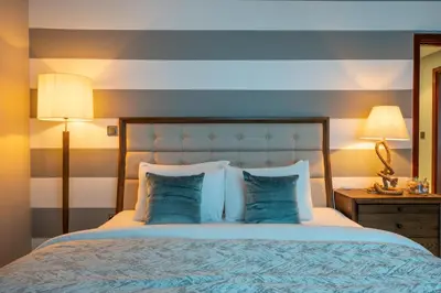 a bedroom with a large bed with blue pillows at Burj Residence by Radiance Vacation Stays in Dubai