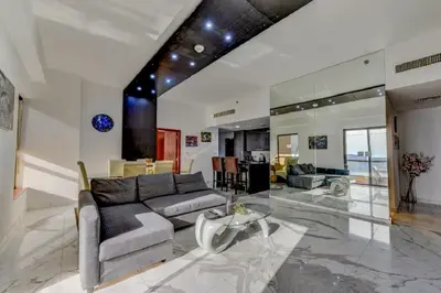 a living room with a couch and a glass table at VIP Castles JBR Rimal 3 Suite 1 Bedroom in Dubai