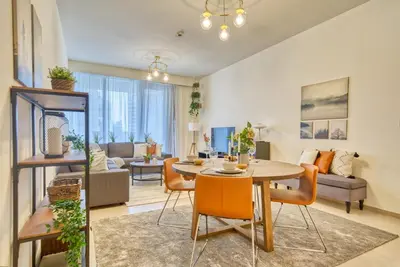 a living room with a table and chairs and a couch at Incredible Views From This Classy Apt With Terrace in Dubai