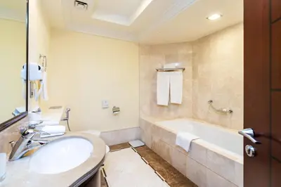 a bathroom with a sink and a bath tub at Royal Club By RVHR, Grandeur Residence Crescent Palm Jumeirah in Dubai