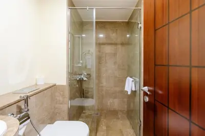 a bathroom with a shower with a toilet and a sink at Royal Club By RVHR, Grandeur Residence Crescent Palm Jumeirah in Dubai
