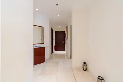 a hallway with white walls and white tile floors at Royal Club By RVHR, Grandeur Residence Crescent Palm Jumeirah in Dubai