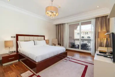 a bedroom with a bed and a desk and a television at Royal Club By RVHR, Grandeur Residence Crescent Palm Jumeirah in Dubai