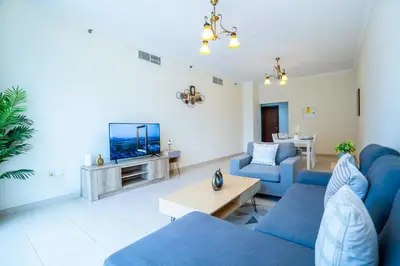 a living room with blue couches and a tv at RH- Prime Location, Spacious 2BR, walk to Dubai Mall in Dubai
