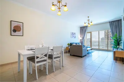 a dining room and living room with a table and chairs at RH- Prime Location, Spacious 2BR, walk to Dubai Mall in Dubai