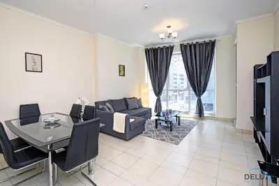 a living room with a couch and a table at Steps Away From the Beach & Entertainment Hubs 1BR Unit, Torch Tower, Dubai Marina by Deluxe Holiday Homes in Dubai