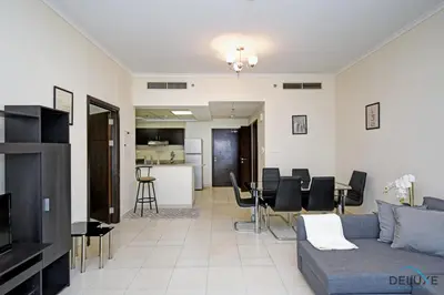 a living room with a couch and a table at Steps Away From the Beach & Entertainment Hubs 1BR Unit, Torch Tower, Dubai Marina by Deluxe Holiday Homes in Dubai
