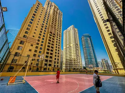 two people playing basketball on a basketball court in a city at HiGuests - Artistic Waterfront Apt, Perfect for Beach Lovers in Dubai