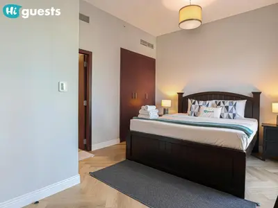 a bedroom with a large bed with a wooden headboard at HiGuests - Artistic Waterfront Apt, Perfect for Beach Lovers in Dubai