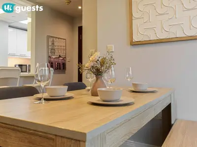 a table with wine glasses and a vase with flowers at HiGuests - Artistic Waterfront Apt, Perfect for Beach Lovers in Dubai