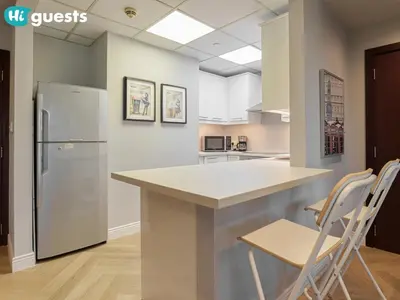 a kitchen with a counter and a refrigerator at HiGuests - Artistic Waterfront Apt, Perfect for Beach Lovers in Dubai