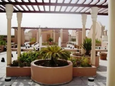 a patio with potted plants and a pergola at Huge Entire apartment for Couples ,families & Groups -up to 5 Guests- with free pool, steam & Sauna ,JVC,Dubai in Dubai