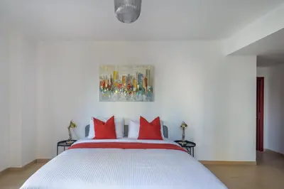 a bedroom with a white bed with red pillows at Frank Porter - Murjan 6 in Dubai