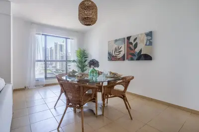 a dining room with a table and chairs and a window at Frank Porter - Murjan 6 in Dubai