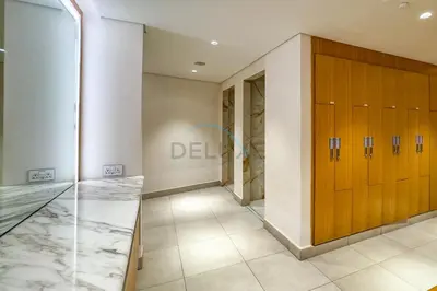 a dressing room with wooden lockers and a hallway at Pristine 2BR with Assistants Room at The Address Residences in JBR by Deluxe Holiday Homes in Dubai